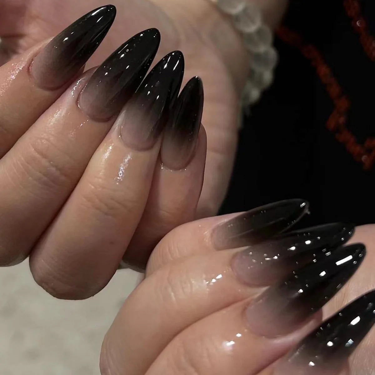 Long pointed decorative nails shown on hands