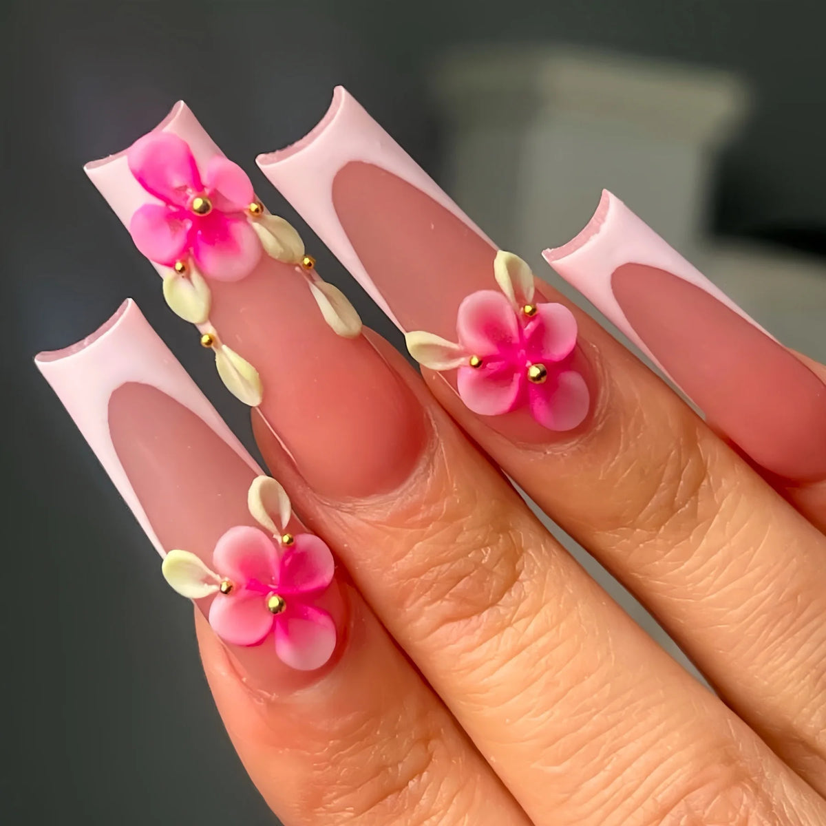 Long decorated nails with raised embellishments shown on hands