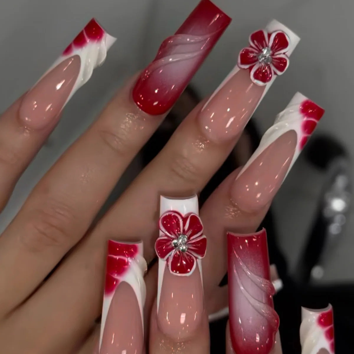 Long decorated nails with raised embellishments shown on hands
