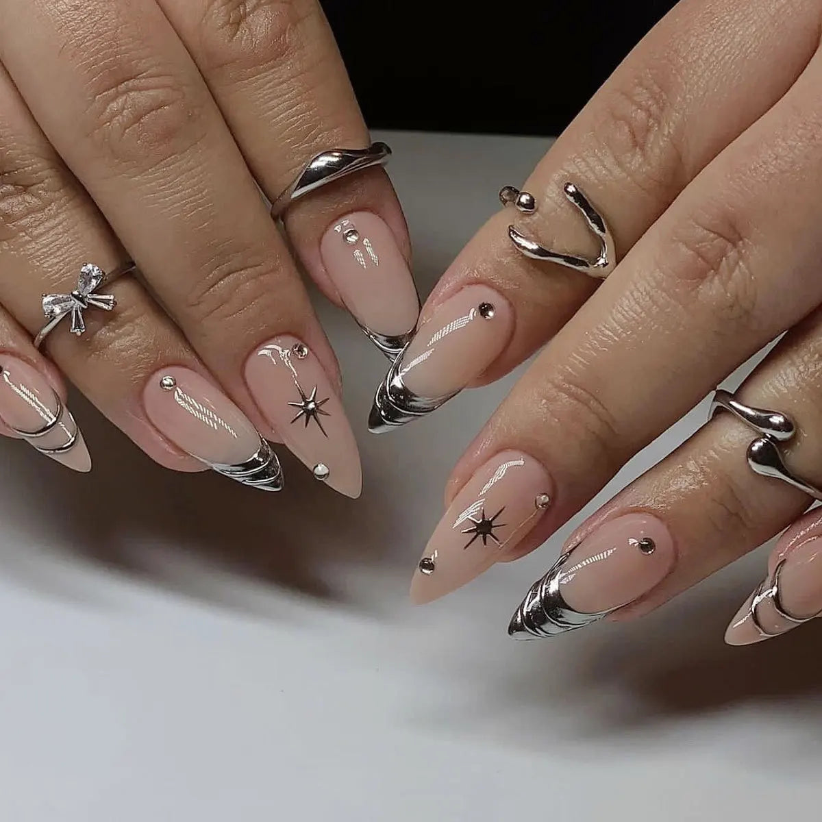 Metallic and embellished nails shown on hands