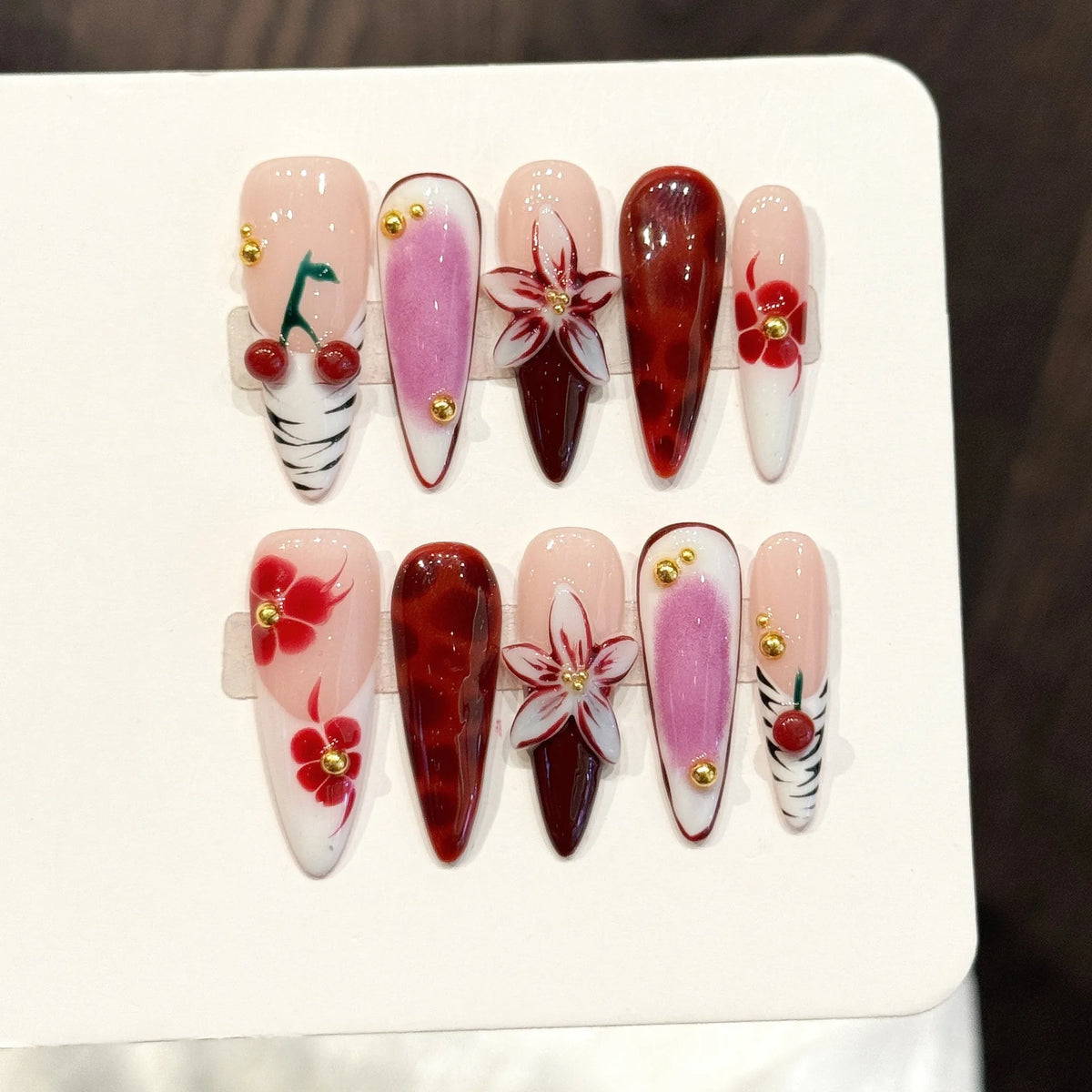 Decorated pointed press-on nails arranged in rows