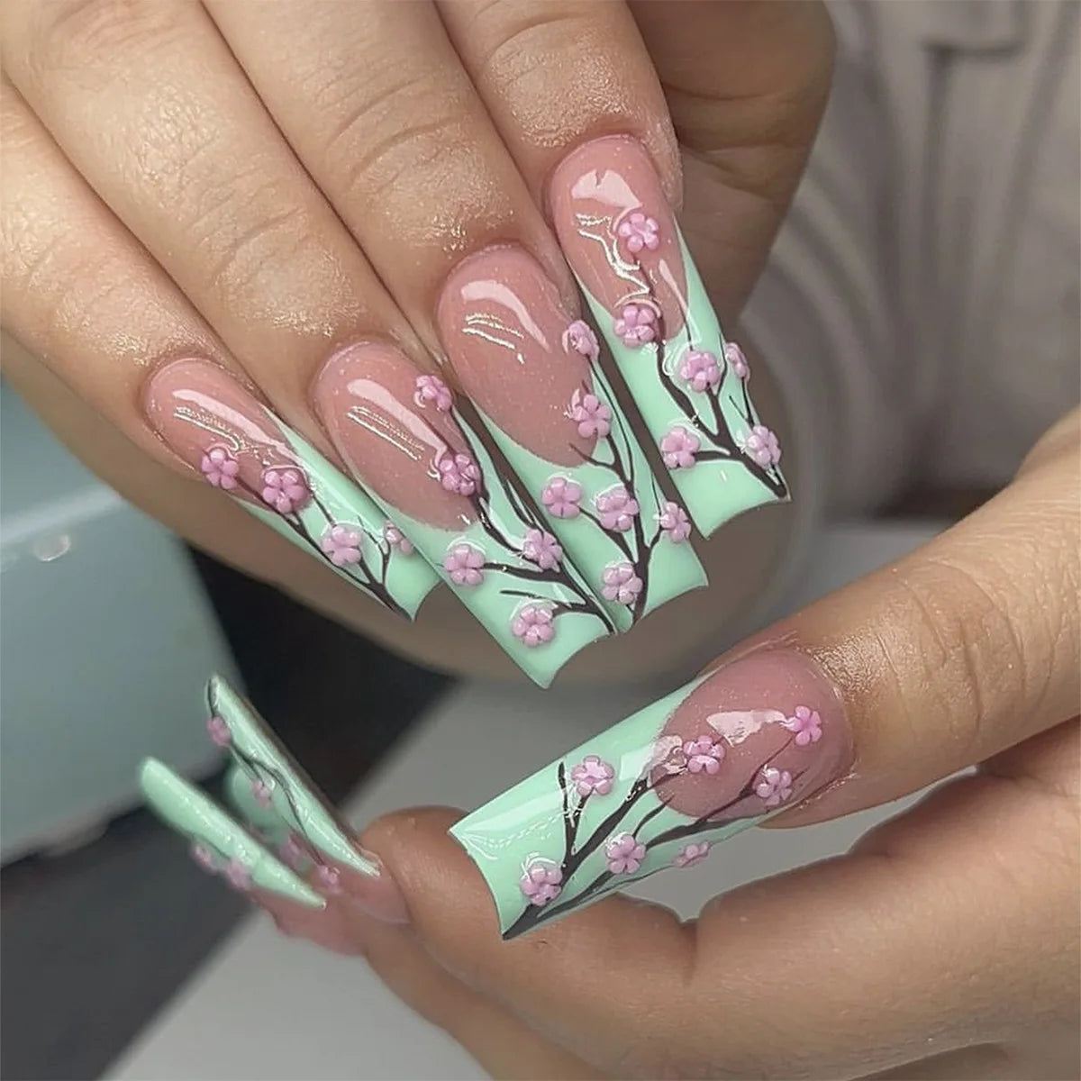 Long decorated nails with raised embellishments shown on hands