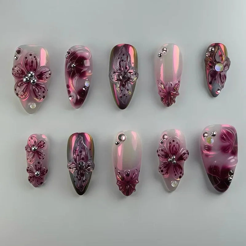Pink and dark floral press-on nails arranged in rows