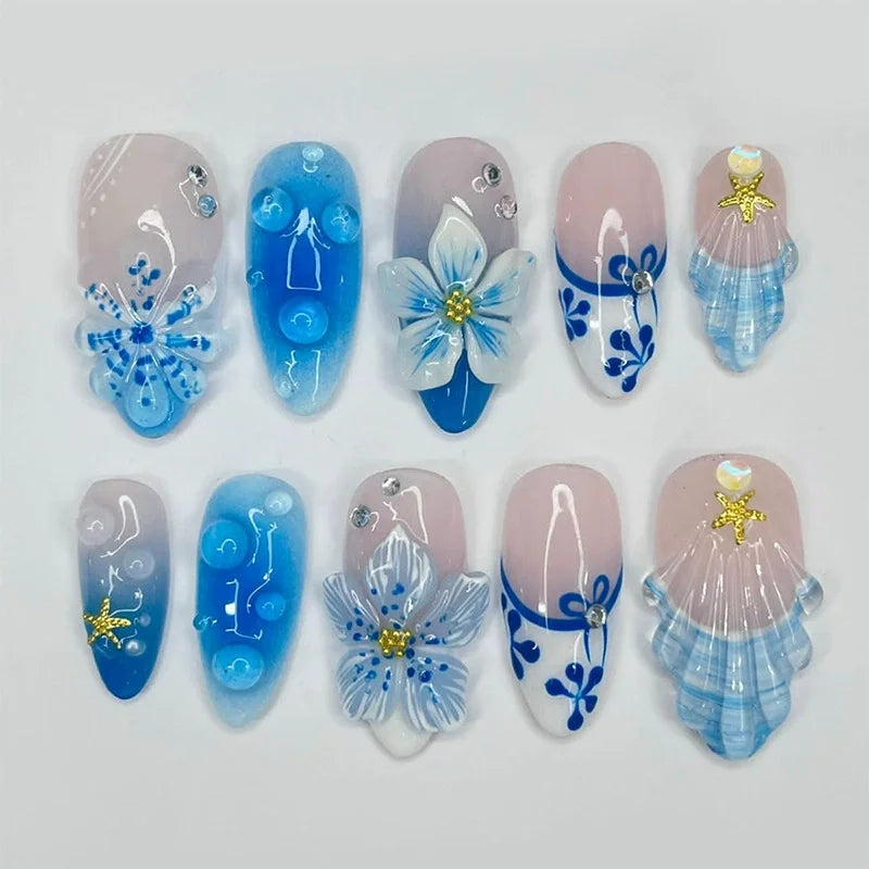 Blue and white floral press-on nails arranged in rows