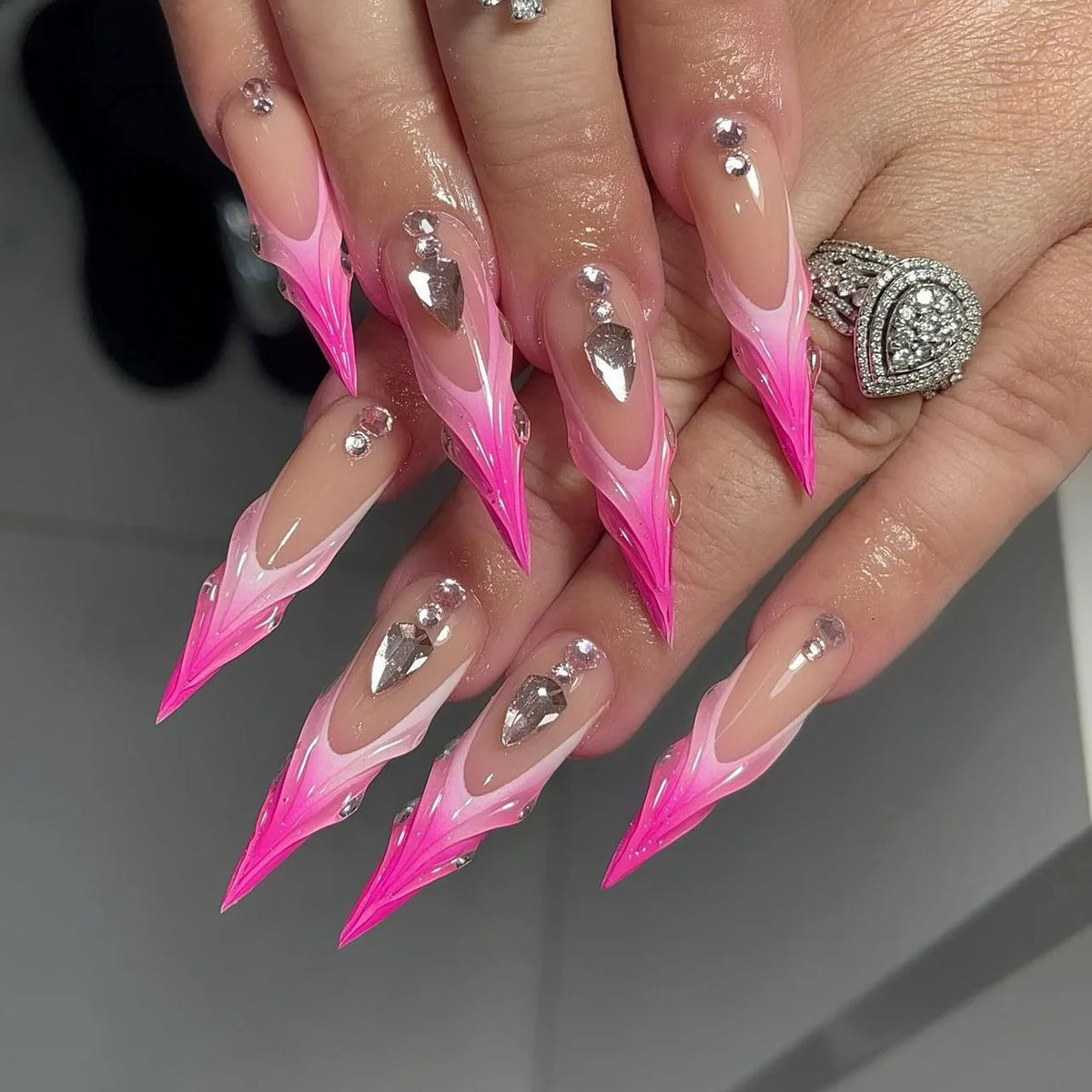 Long decorative nail designs with raised accents shown on hands