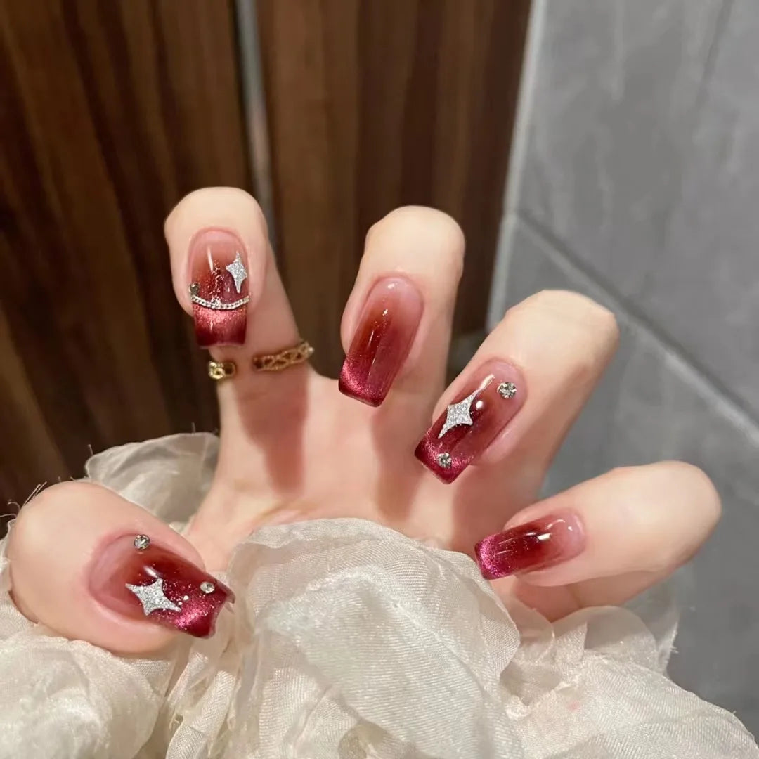 Red decorative nails shown on a hand