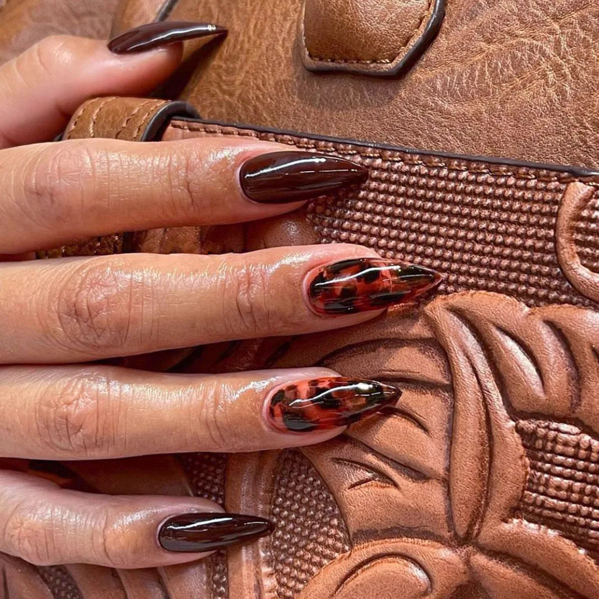 Long pointed decorative nails shown on hands