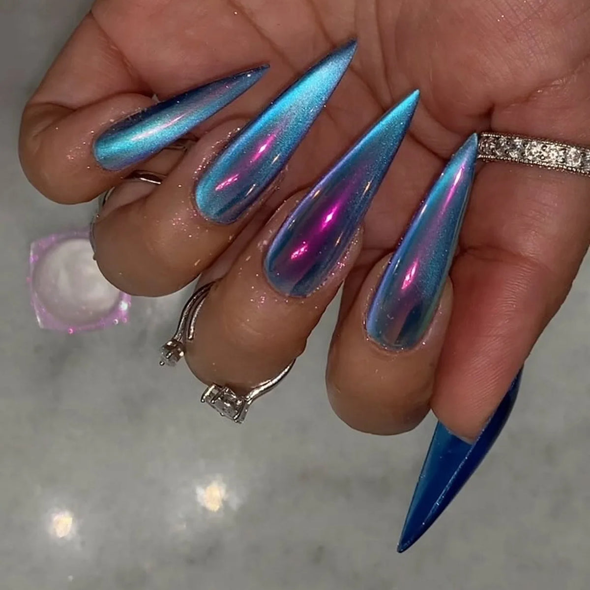 Long decorated nails shown on hands