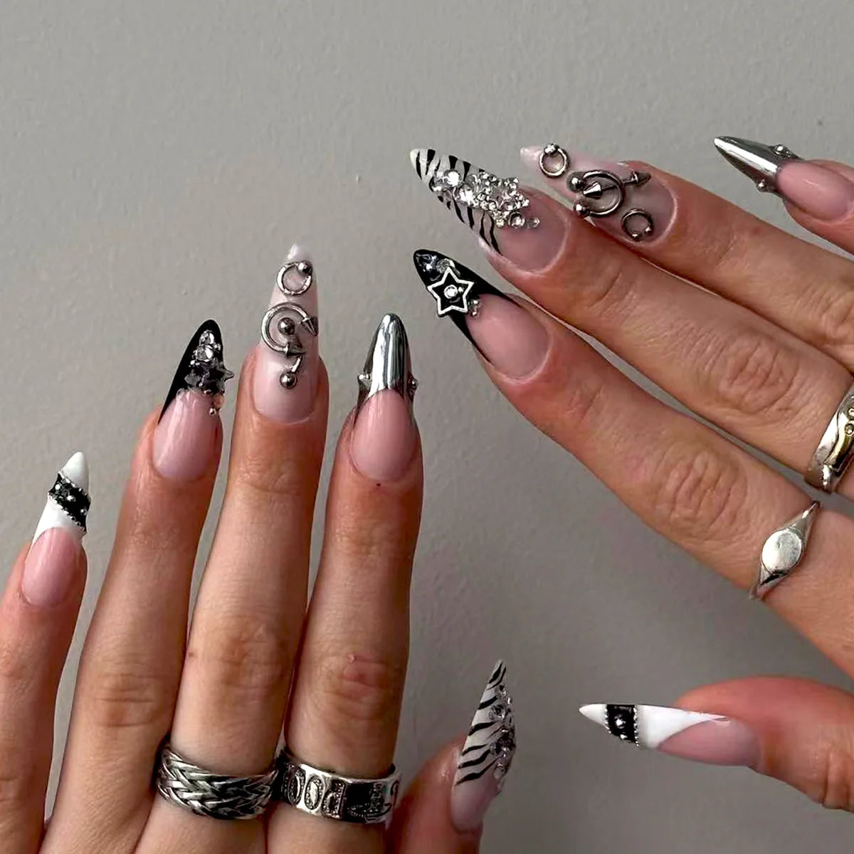 Long embellished pointed nail designs shown on hands