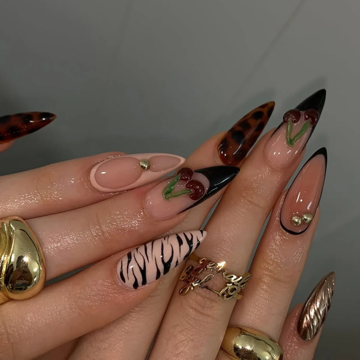 Decorative floral and embellished nail designs shown on hands