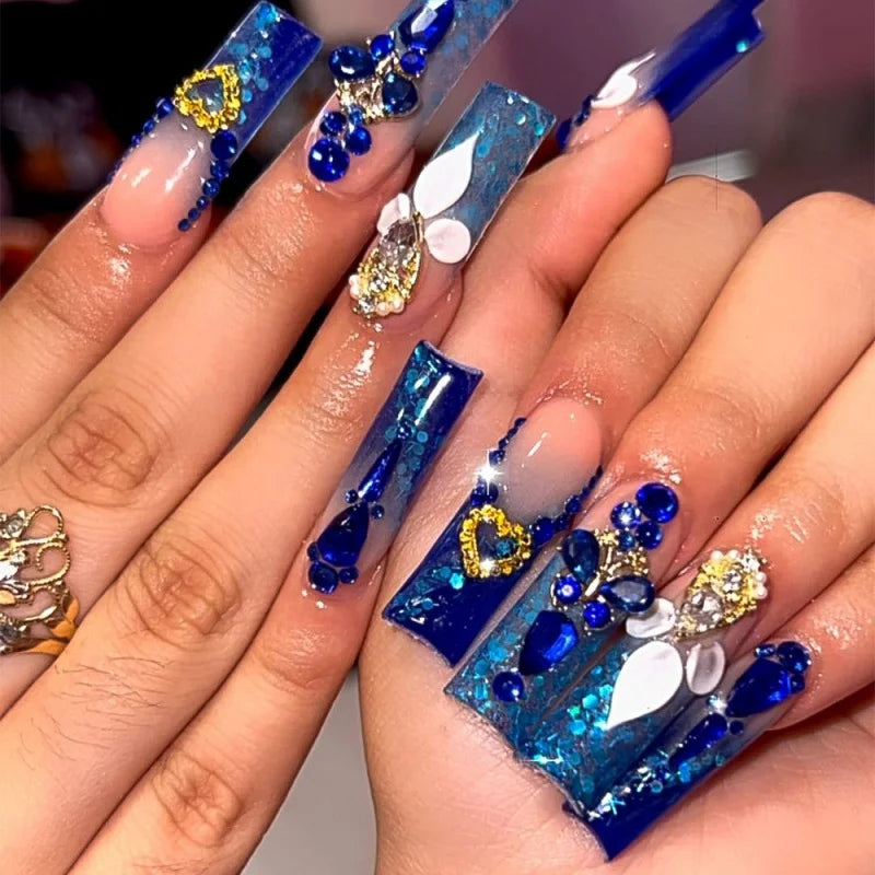 Decorative nail designs with floral, metallic or gem accents shown on hands