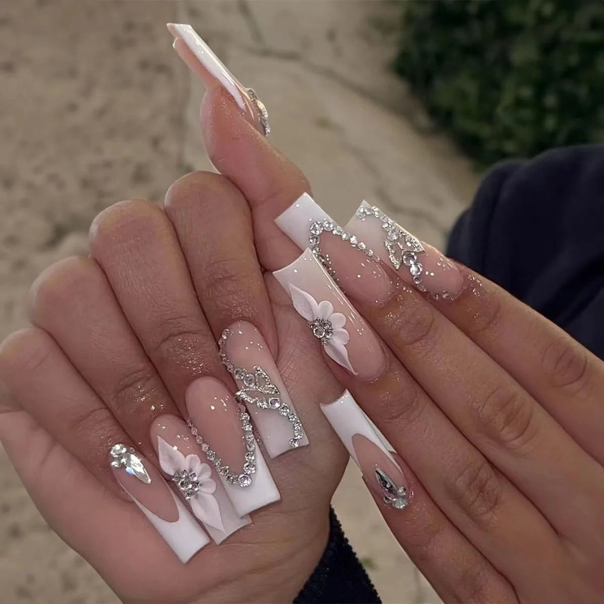 Long decorated nails with raised embellishments shown on hands