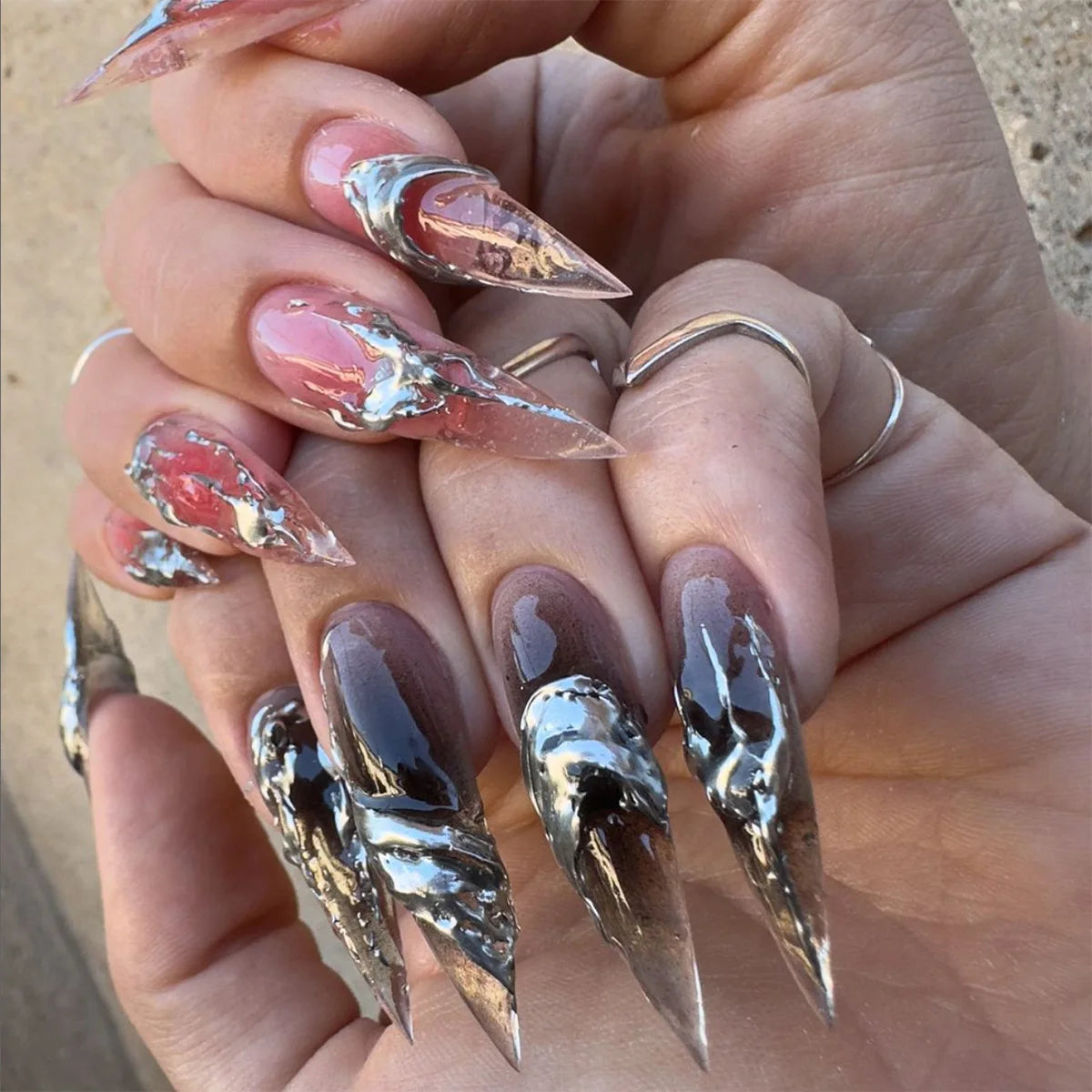 Decorative nail designs with floral, metallic or gem accents shown on hands