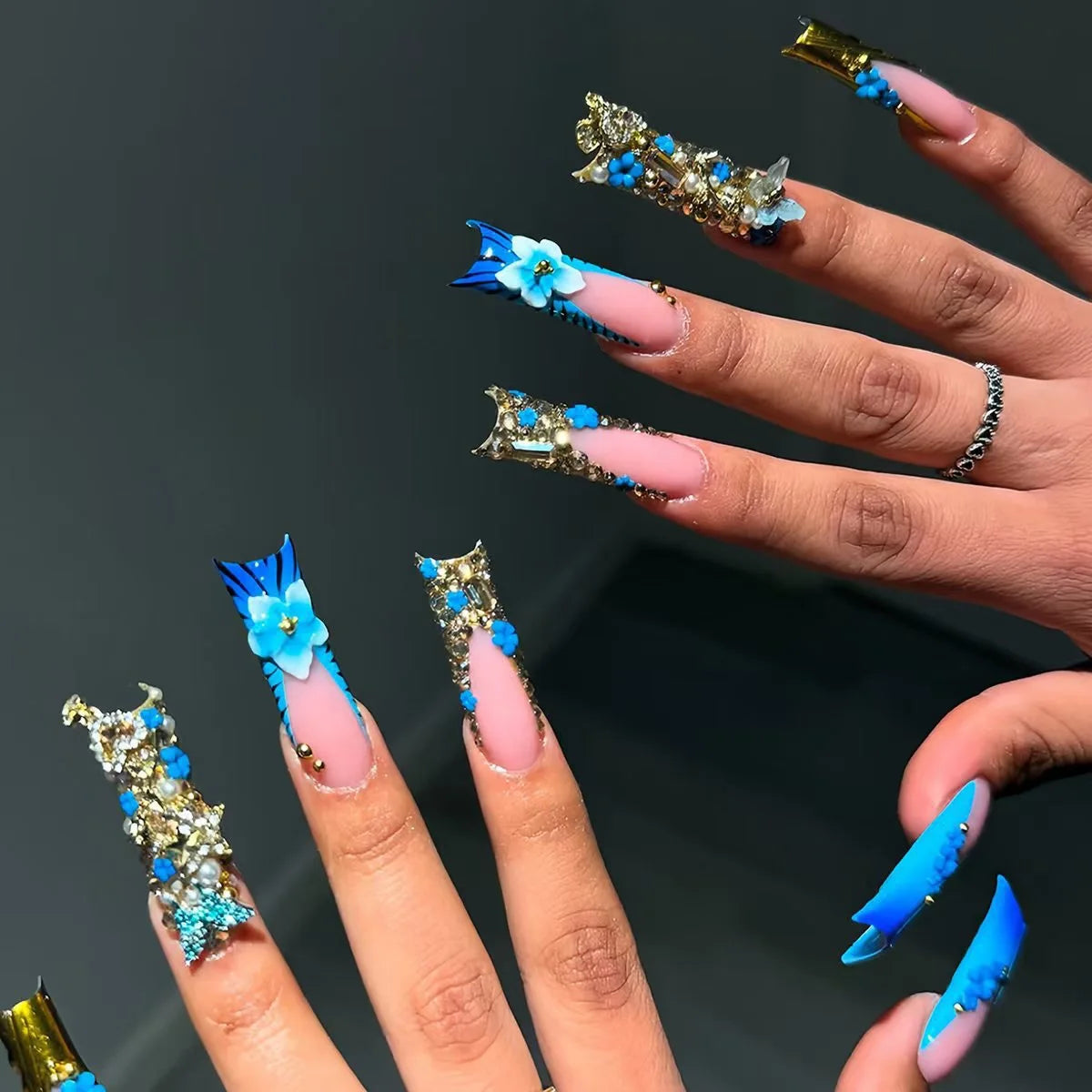 Long decorated nails with raised embellishments shown on hands