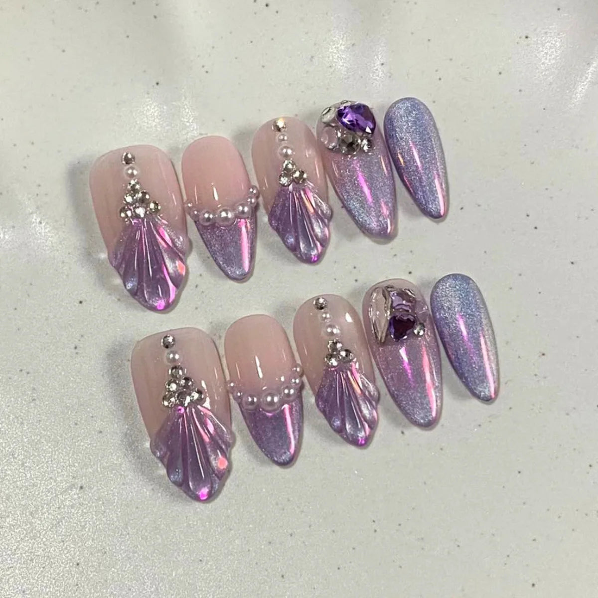 Purple decorative press-on nails arranged in rows