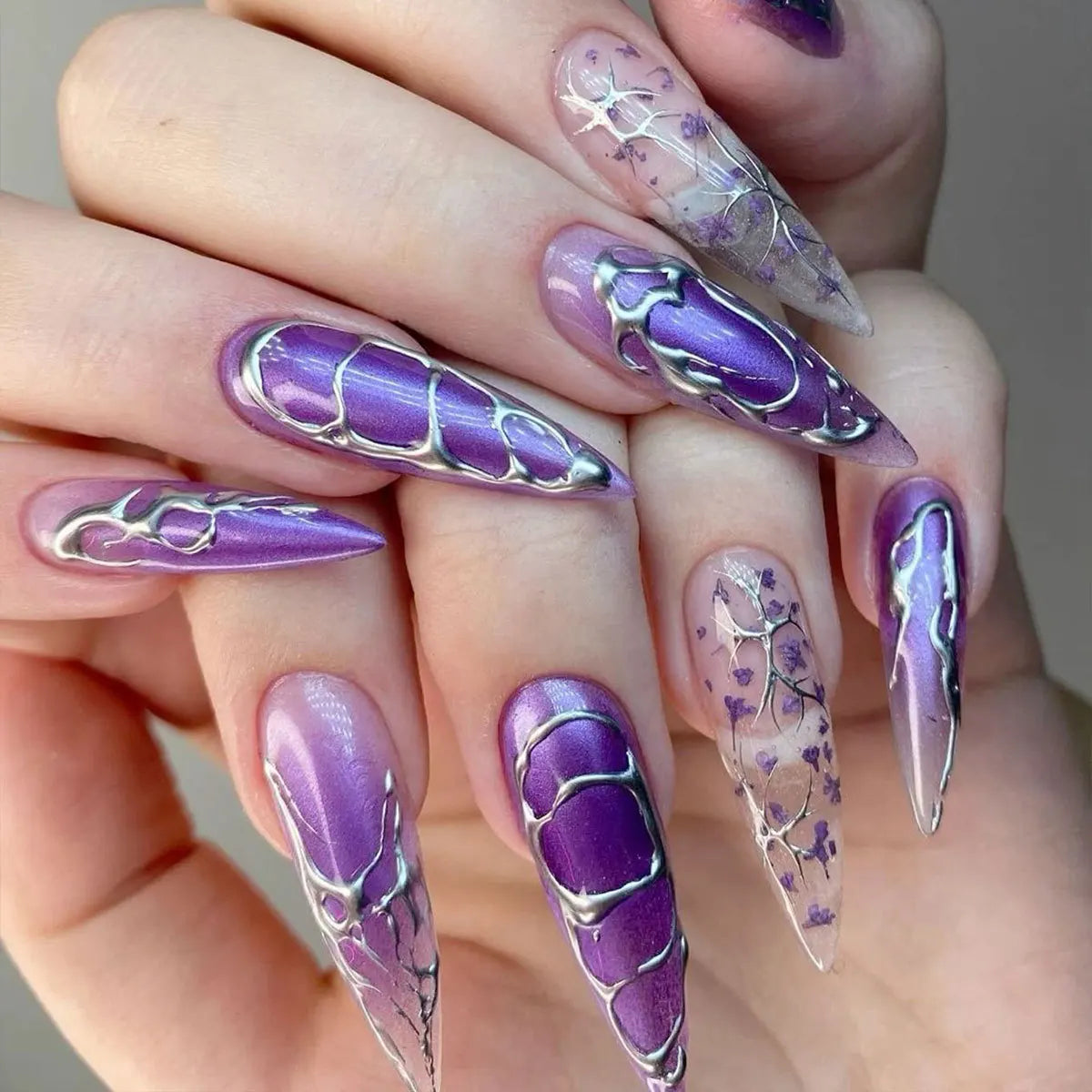 Long decorative nail designs with raised accents shown on hands