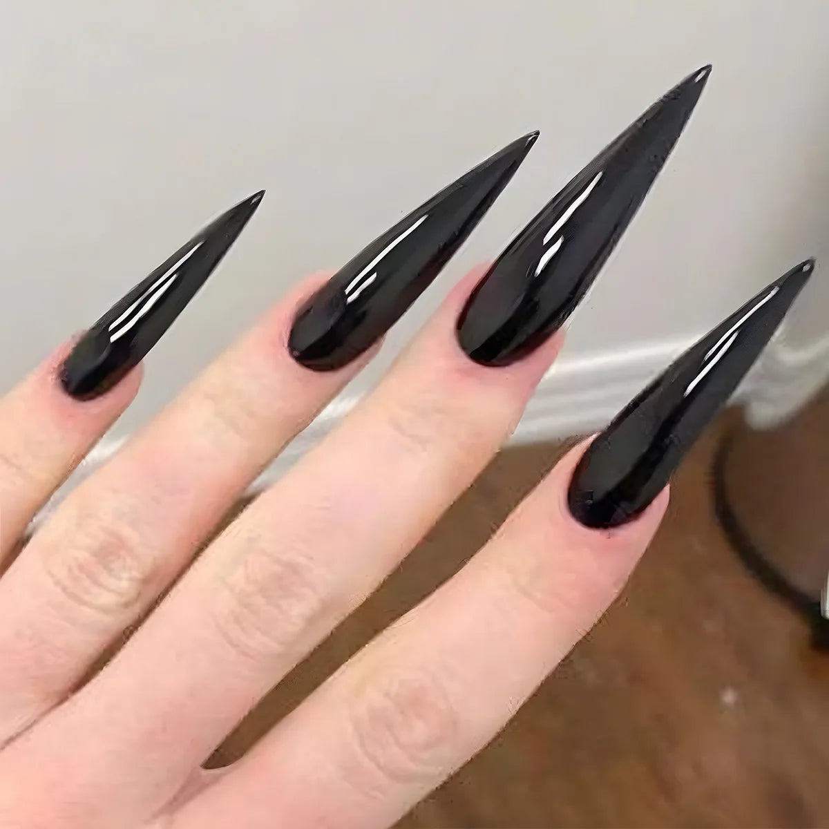 Long pointed decorative nails shown on hands