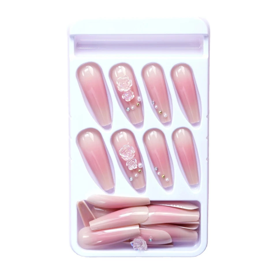 Pink press-on nail kit in a tray with manicure accessories