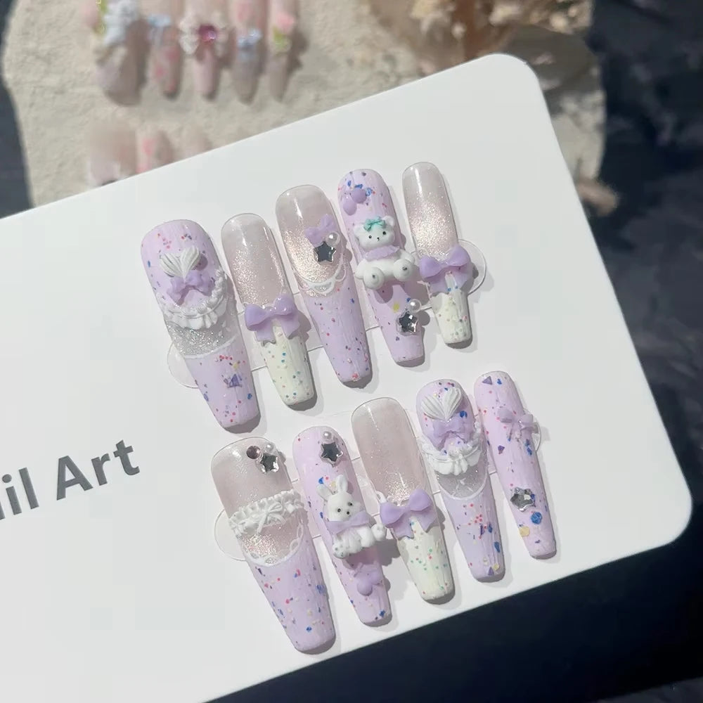 Decorated press-on nail sets with raised embellishments on display cards