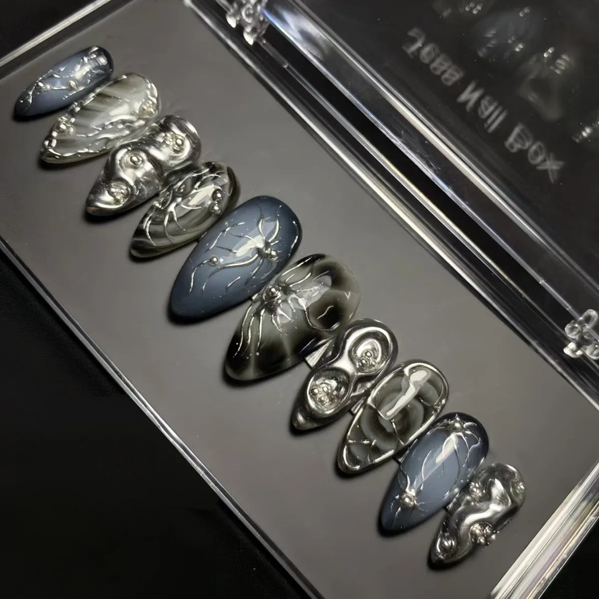 Metallic decorated press-on nails arranged on a tray