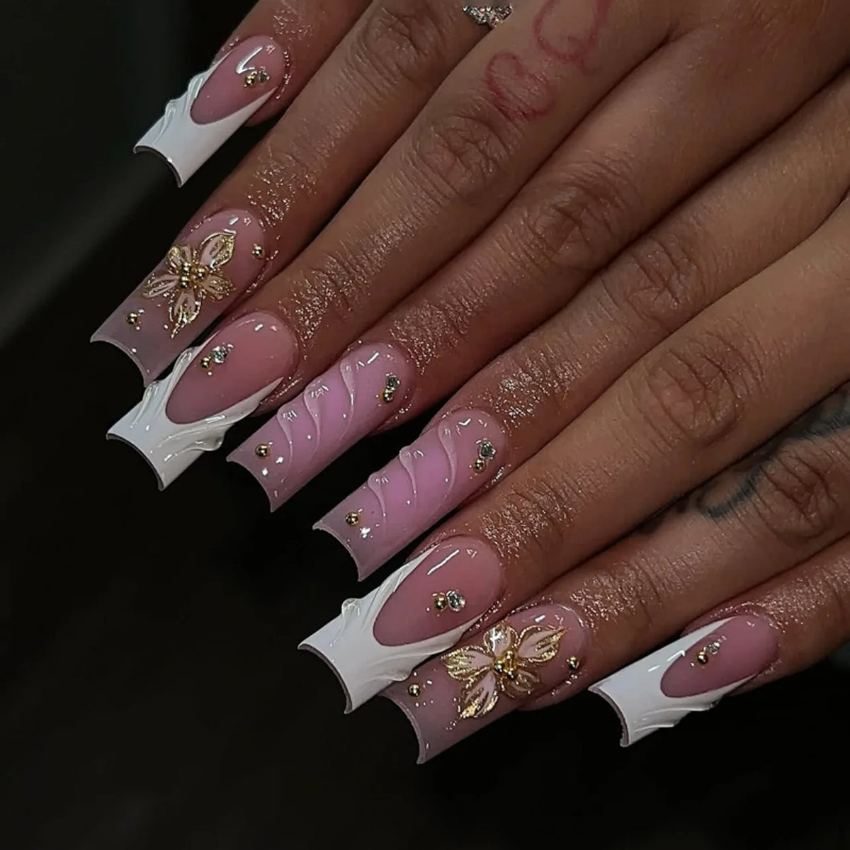 Long decorated nails with raised embellishments shown on hands