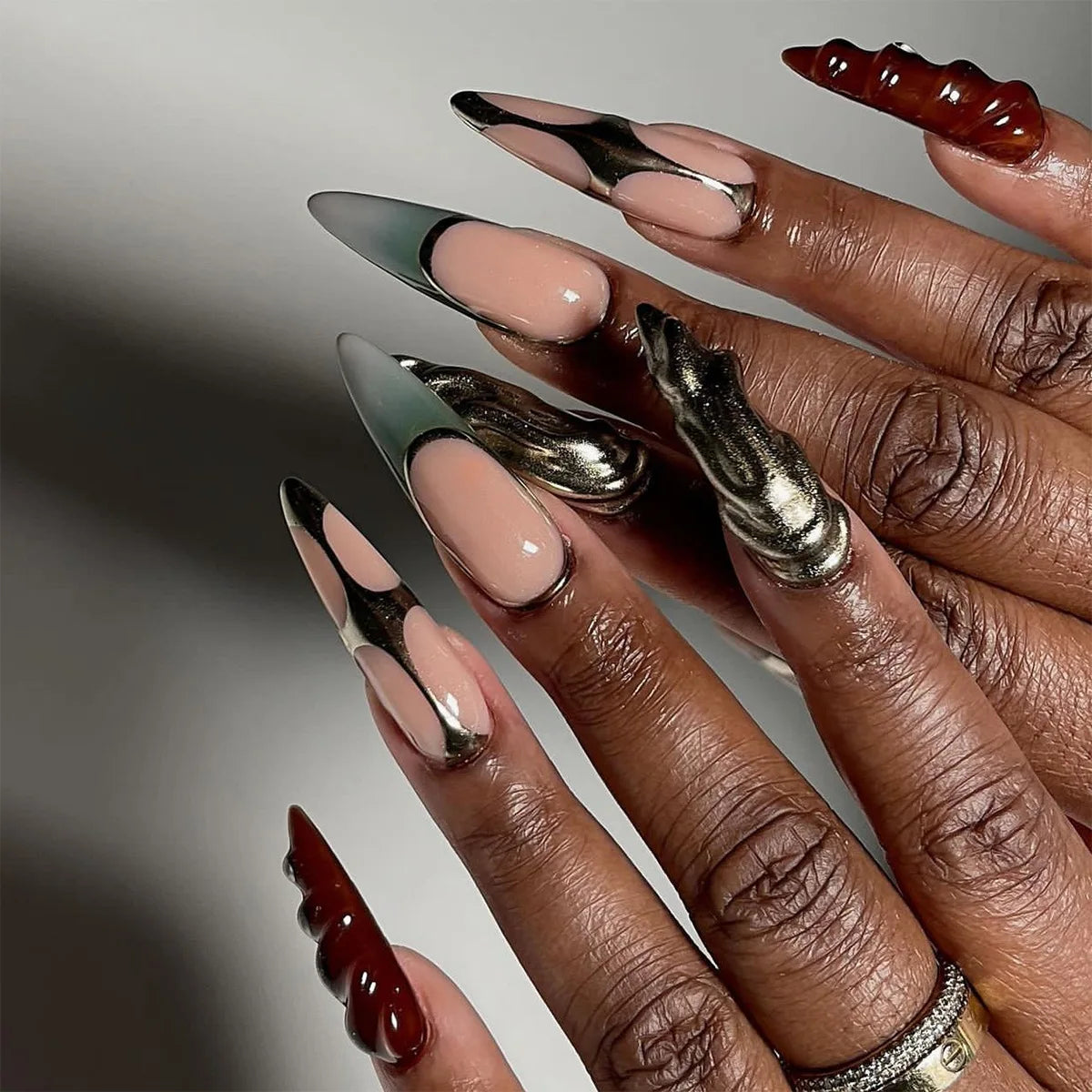 Long embellished pointed nail designs shown on hands