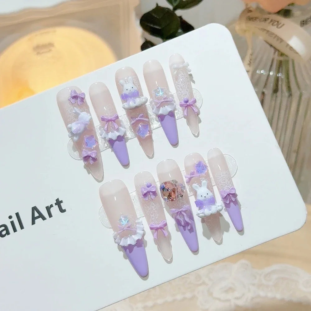 Decorated press-on nail sets with raised embellishments on display cards