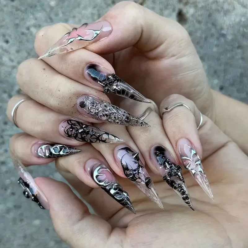 Long embellished pointed nail designs shown on hands