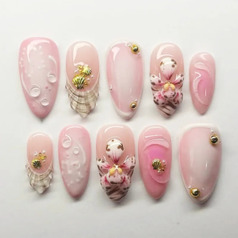 Pink decorated press-on nails arranged in rows
