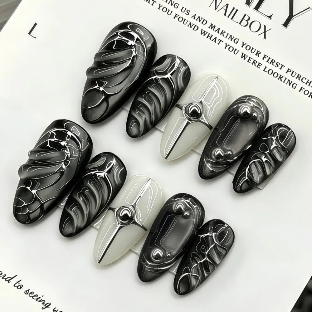 Dark decorated press-on nails arranged in rows