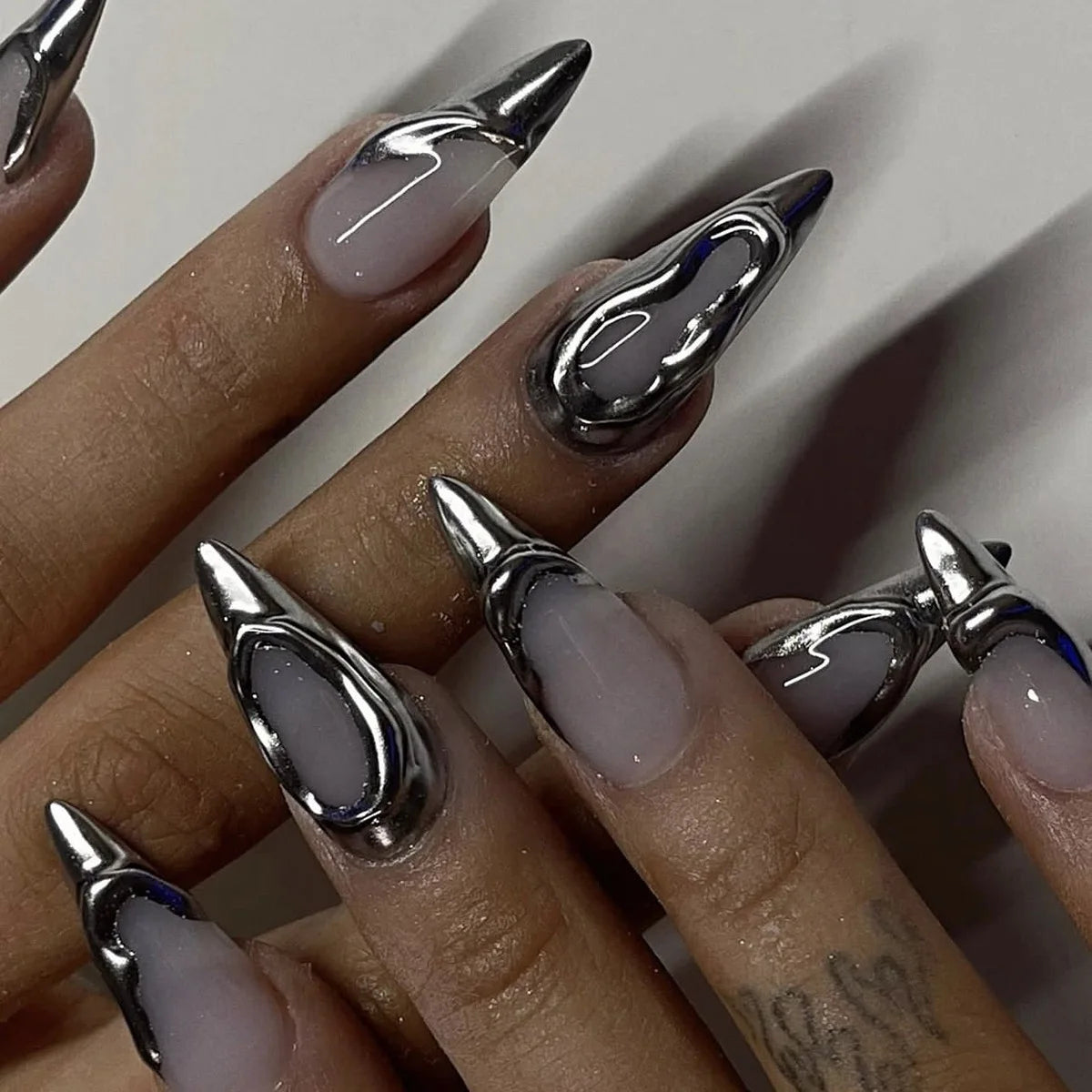 Long decorative nail designs with raised accents shown on hands