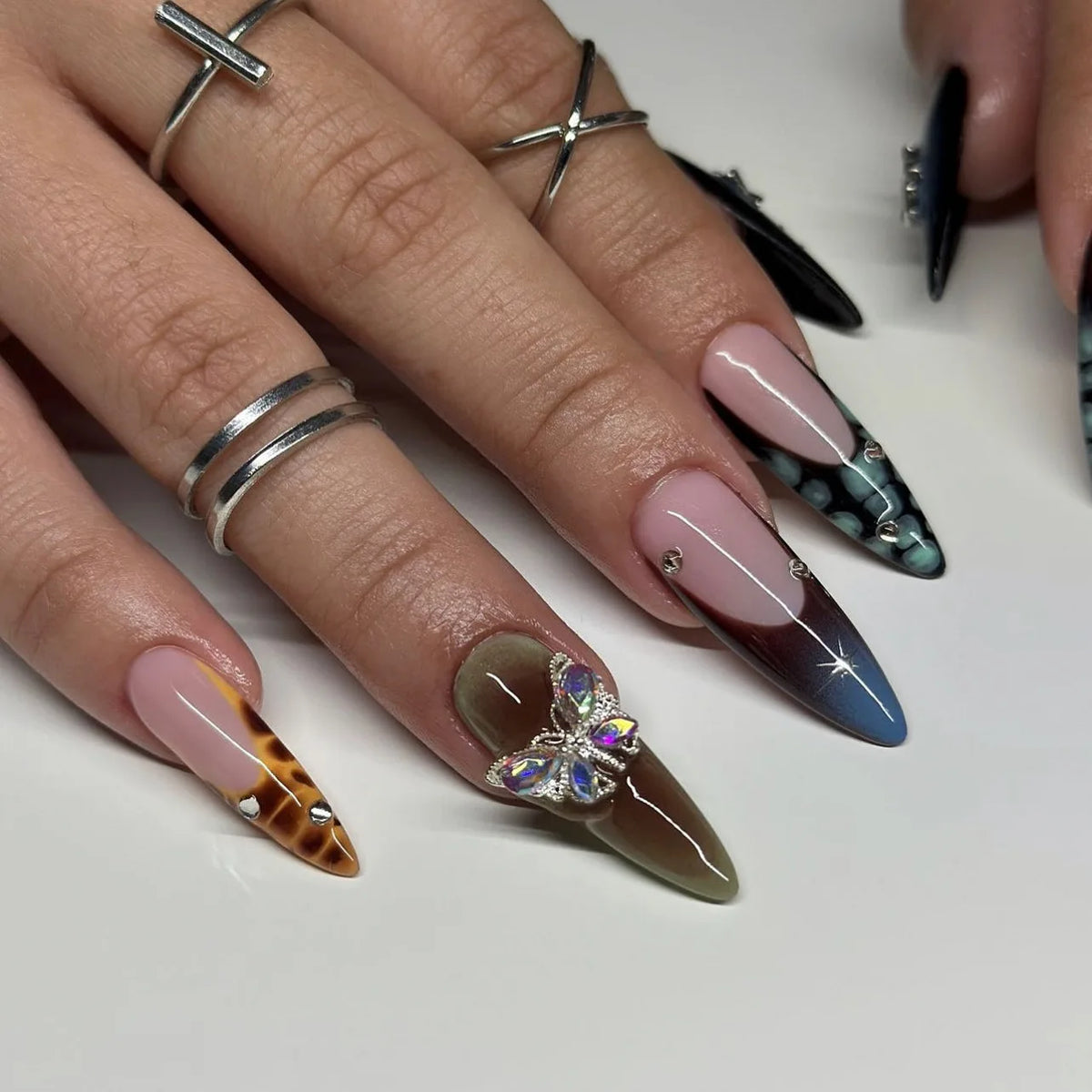 Long pointed decorative nails shown on hands