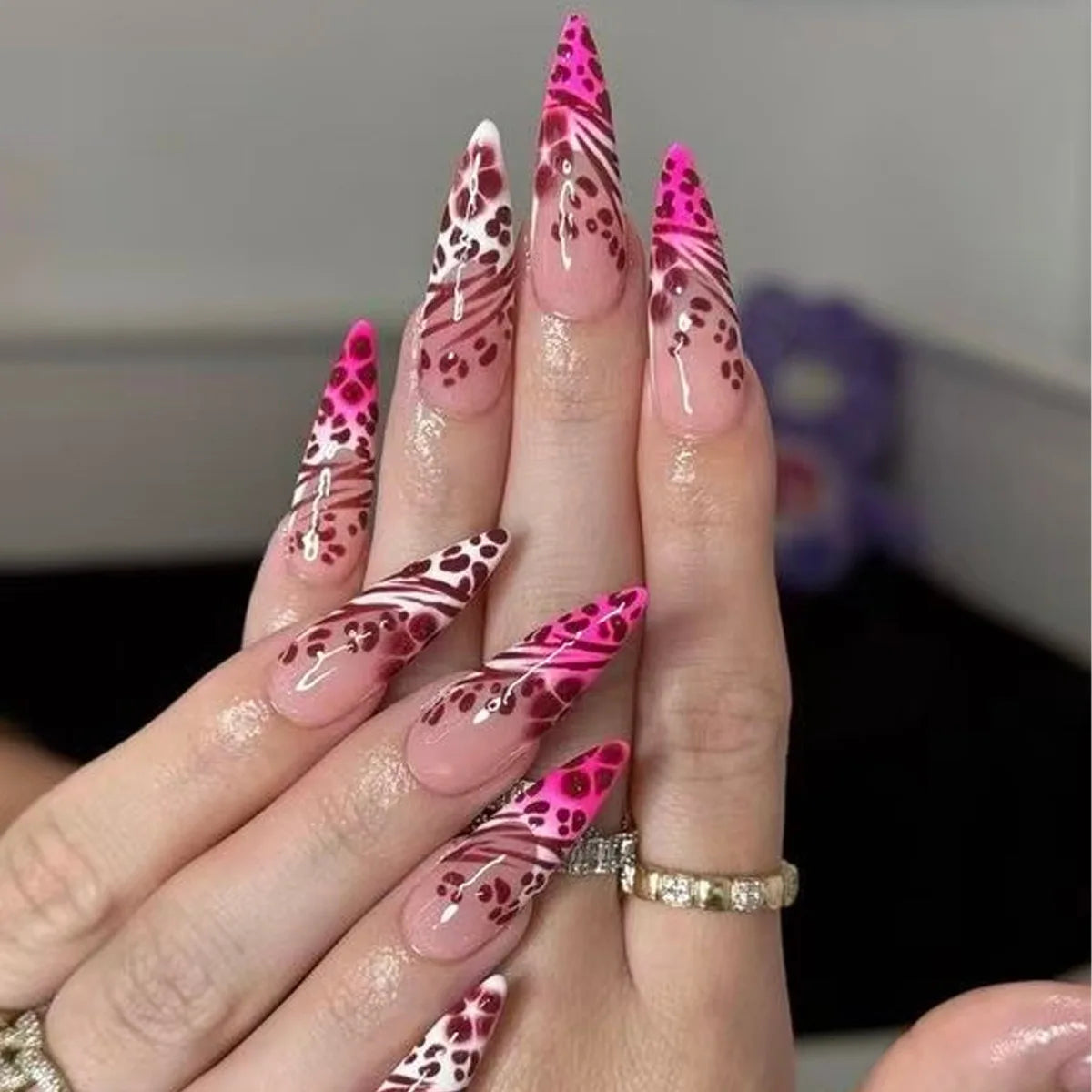 Long embellished pointed nail designs shown on hands