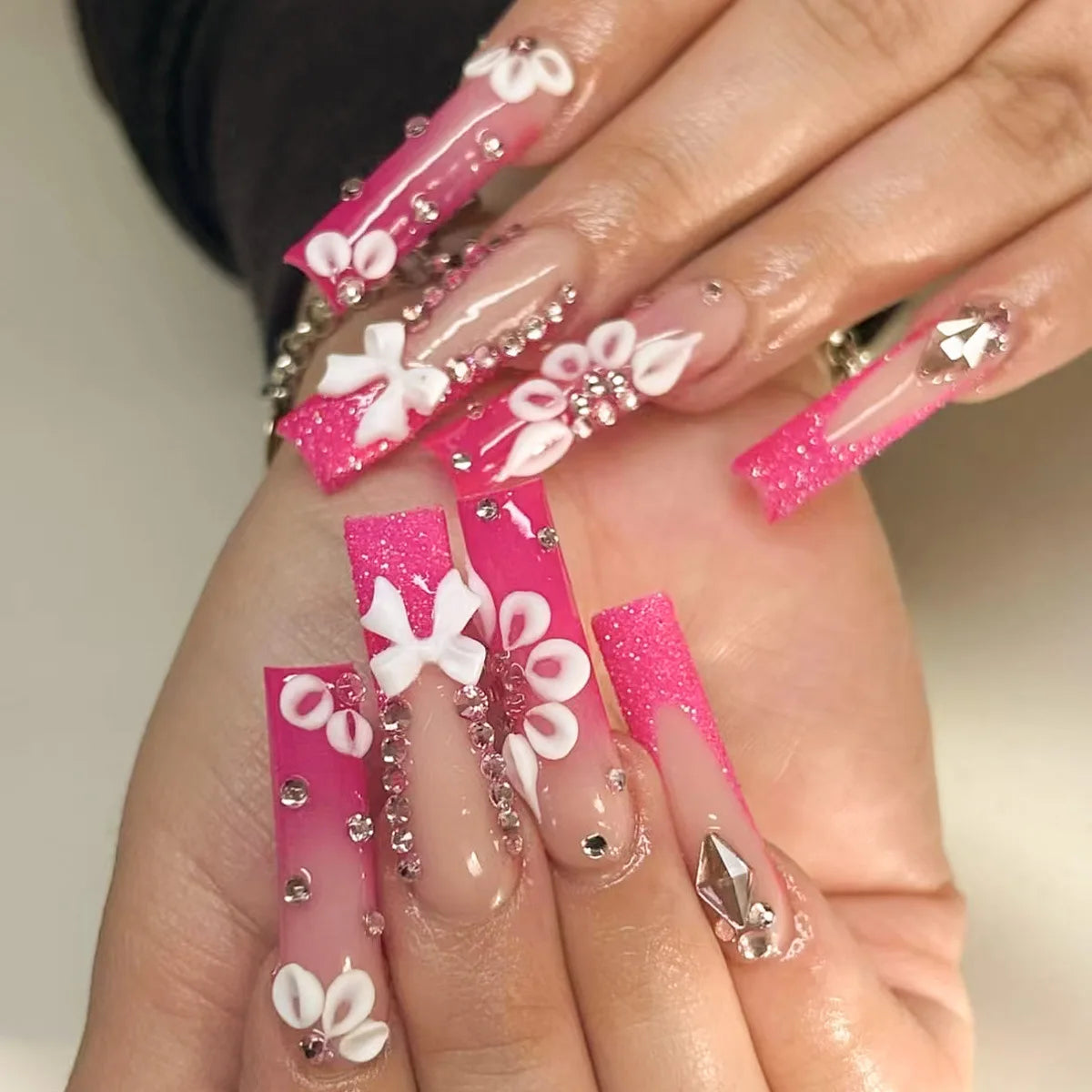 Long decorated nail designs shown on hands